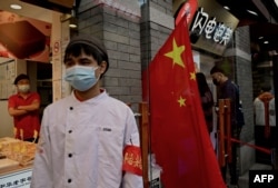 中國國旗假日期間，北京南鑼鼓巷胡同的一名治安員在值勤。 （2022年10月3日）