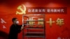 一名工作人員在北京一家酒店的中共二十大新聞中心走過宣傳中國領導人習近平的標語。（2022年10月19日）