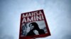 FILE - A woman holds a placard with a picture of Iranian Mahsa Amini during a protest against her death, in Berlin, Germany, Sept. 28, 2022. 