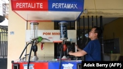 FILE - Seorang petugas pompa bensin di sebuah SPBU pinggir jalan di Jakarta, 29 Mei 2022. (ADEK BERRY/AFP)