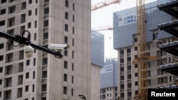 上海一處正在修建的公寓樓盤旁豎立著一個監控攝像頭。（2022年7月20日）