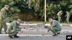 Na ovoj fotografiji napravljenoj od video-snimka Istražnog komiteta Rusije u nedelju, 21. avgusta 2022, istražitelji rade na mestu eksplozije automobila koji je vozila Darija Dugina, nedaleko od Moskve.
