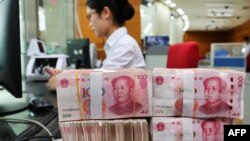 资料照片: 2018年7月23日中国江苏省南通市一家银行员工处理100元纸币。