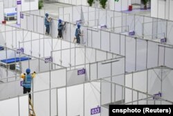 资料照：中国广东广州的工人在琶洲国际会展中心为新冠疫情修建方舱。（2022年4月10日）