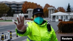 Čuvar sprečava slikanje na ulazu u Univerzitet Cingua u Pekingu (Foto: REUTERS/Thomas Peter)