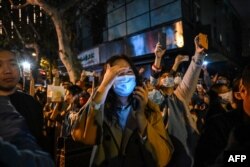 People gather on a street in Shanghai on Nov. 27, 2022, where protests against China's zero-COVID policy took place the night before following a deadly fire in Urumqi, the capital of the Xinjiang region.
