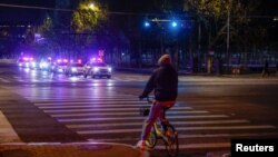 Police cars patrol a street in an area where a message that circulated online called on people to gather for a protest against COVID-19 restrictions in Beijing, Nov. 29, 2022.