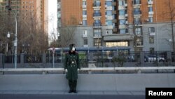 A member of the Chinese People's Armed Police Force wears a face mask as he keeps watch on a street amid COVID-19 outbreaks in Beijing, Dec. 1, 2022.