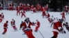 Para pemain ski berpakaian Santa berpartisipasi dalam acara amal di resor ski Sunday River di Bethel, Maine, AS, 5 Desember 2021. REUTERS/Brian Snyder