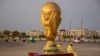 Pekerja duduk di samping replika Piala Dunia di luar Stadion Lusail jelang Piala Dunia, di Lusail, Qatar, 10 November 2022 REUTERS/Marko Djurica