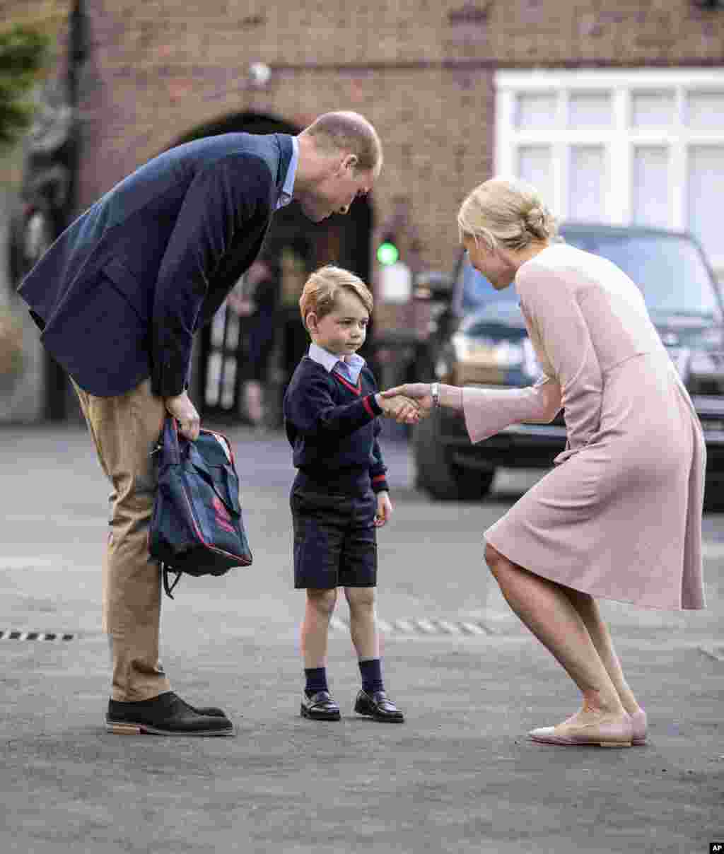 Prince George holding the hand of his father, Prince William, Duke of Cambridge, arrives for his first day of school at Thomas's school in Battersea, London.