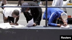 FILE - AbeZimbabwe baloba amaphepha okuhlala lokusebenza kwele South Africa.