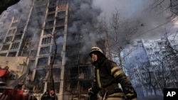 2022年3月15日烏克蘭首都基輔一名消防人員在遭到炮火摧毀的一棟公寓樓前
