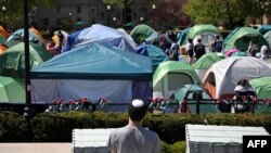 FILE - Seorang pria Yahudi menyaksikan mahasiswa dan aktivis pro-Palestina berkumpul di perkemahan protes di kampus Universitas Columbia di New York City, 25 April 2024.