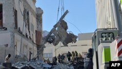 Rescue workers clear the rubble of a building of the Kharkiv Regional Institute of Public Administration damaged by shelling, March 18, 2022, amid Russia's invasion of Ukraine. 