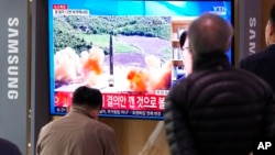 Ljudi gledaju TV program i emisiju veti tokom koje je prikazana arhivsta fotografija severnokorejskog lansiranja rakete, na železničkoj stanici u Seulu, Južna Koreja, 24. marta 2022.