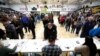 A precinct secretary and other officials look over documents at a caucus in Des Moines, Iowa, Feb. 3, 2020.