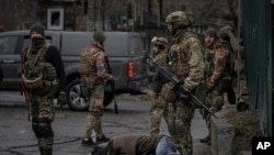 Ukrajinski vojnici pored tela civila u Buči, predgrađu Kijeva (Foto:AP)