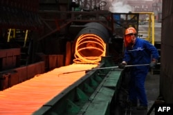 FILE - A Chinese employee sorts hot red steel at a steel plant in Zouping in China's eastern Shandong province, March 5, 2018. China has warned this month that it will retaliate if the United States damages its economic interests.