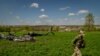 A Ukrainian soldier walks away from the site where a Russian helicopter was shot down during battle in the village of Malaya Rohan, outside Kharkiv, April 30, 2022.