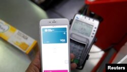 FILE - A shopper uses the mobile payment service Apple Pay at a supermarket, in Ronda, southern Spain, Oct. 9, 2020. 