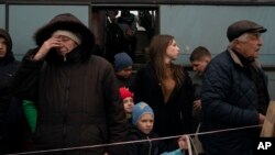 Adults and children from Mariupol and nearby towns step out a bus, having arrived at a refugee center fleeing from the war, in Zaporizhzhia, Ukraine, April 21, 2022.