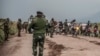 FILE - People walk along a road near Kibumba, north of Goma, Democratic Republic of Congo, as they flee fighting between Congolese forces and M23 rebels in North Kivu, May 24, 2022. 