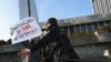 Polisi menahan seorang pendemo yang memprotes undang-undang media baru di Azerbaijan dalam aksi di depan gedung parlemen di Baku, Azerbaijan, pada 28 Desember 2021. (Foto: Reuters/Aziz Karimov)