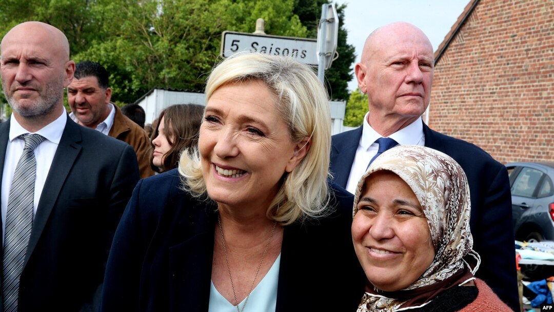 FILE - French far-right party Rassemblement National's (RN) leader Marine Le Pen, poses for a photograph as she visits a local flee market as she begins her campaigning for the upcoming legislative elections, in Henin-Beaumont, northern France, May 8, 2022.