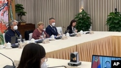 2022年5月24日，聯合國人權事務高級專員巴切萊特（左二）在廣州與中國公安部副部長杜航偉（右邊電腦屏幕上）舉行視頻會議。 （照片由聯合國人權高專辦通過美聯社向外界發布。）