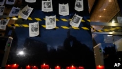FILE - Photos of slain journalists on a wall during a vigil to protest the murder of journalist Fredid Roman, in Mexico City, Aug. 24, 2022. 