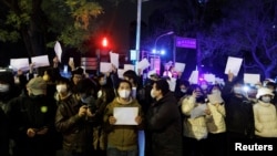 2022年11月28日，在中國北京，隨著新冠肺炎疫情的持續，人們在為烏魯木齊火災罹難者守夜後，手持白紙抗議新冠肺炎疫情限制措施。