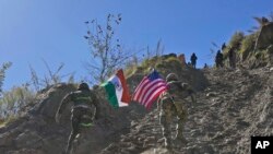 2022年11月30日，印度和美國陸軍士兵舉著各自國家的國旗，在印美聯合演習期間跑上一座小山。(美聯社照片）