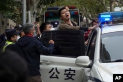 上海警察逮捕了一名抗议中国严厉防疫政策的青年。（2022年11月27日）