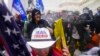 Para loyalis mantan Presiden Donald Trump mencoba mendobrak barikade polisi di Gedung Capitol, Washington, dalam aksi penyerbuan terhadap gedung tersebut pada 6 Januari 2021. (Foto: AP/John Minchillo) 