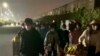 FILE - In this photo taken from video footage and released by Hangpai Xingyang, people with suitcases and bags are seen leaving from a Foxconn compound in Zhengzhou in central China's Henan Province on Oct. 29, 2022. 
