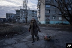 Svetlana, 57, nosi potrepštine u Stari-Saltivu, region Harkova u Ukrajini, 29. decembra 2022. Ljudi u toj oblasti žive bez vode i struje više o šest meseci.