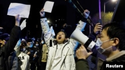 2022年11月28日，在新冠病毒疫情持續擴散之際，北京民眾為烏魯木齊火災罹難者守夜後，舉著白紙抗議中共當局的封控限制。