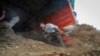 FILE - Farmers offload livestock manure from a truck, that will be used to fertilize crops, in Kiambu, near Nairobi, in Kenya, March 31, 2022. Russia's war in Ukraine has pushed up fertilizer prices and made scarce supplies rarer still.