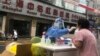 FILE - A medical worker wearing protective gear conducts COVID-19 tests on residents in Shanghai, China, April 10, 2022.