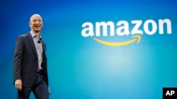 FILE - Amazon CEO Jeff Bezos walks onstage for the launch of the new Amazon Fire Phone, in Seattle, June 16, 2014.