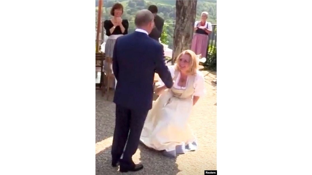 Austria's Foreign Minister Karin Kneissl dances with Russia's President Vladimir Putin at her wedding in Gamlitz, Austria, Aug. 18, 2018, in this picture grab taken from video. Kneissl's critics saw her curtsy to Putin as a sign of submission.