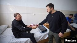 Ukrajinski predsednik Volodimir Zelenski predaje odlikovanje ranjenom ukrajinskom vojniku, tokom posete bolnici u Nikolajevu, Ukrajina, 20. oktobra 2023.
