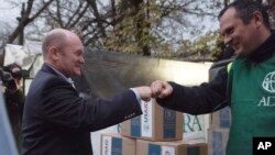 ამერიკელი სენატორი კრის კუნსი USAID-ის სადისტრიბუციო ცენტრში უკრაინელ მოხალისეს ხვდება. კიევი, უკრაინა. 3 ნოემბერი, 2022 წ. 