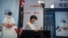 FILE - A staff member demonstrates live streaming at a booth from Chinese technology firm Alibaba at the China International Fair for Trade in Services in Beijing Sept. 2, 2022. The U.S. expanded export controls on advanced chips, including those used for artificial intelligence.