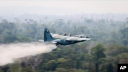 Na ovoj fotografiji koju je objavilo brazilsko ministarstvo odbrane, avion C-130 Hercules izbacuje vodu na prašumu u oblasti Amazona, u Brazilu, 24. avgusta 2019.