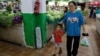 FILE - Customers shop for groceries at a morning market in Beijing, Aug. 9, 2023. 
