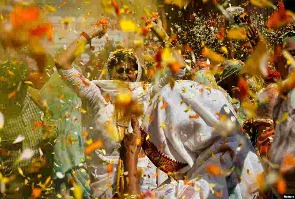 Para janda menari saat ambil bagian dalam perayaan festival Holi di dalam sebuah kuil di Vrindavan, di negara bagian utara Uttar Pradesh, India. (Reuters)