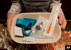 FILE - Registered nurse Sammy Mullally holds a tray of supplies to be used by a drug addict at the Insite safe injection clinic in Vancouver, B.C., Canada.
