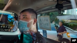 香港首位被控涉嫌違反國安法的男子唐英傑（Tong Ying-kit）坐著輪椅由警車押解至法院應訊。（2020年7月6日）